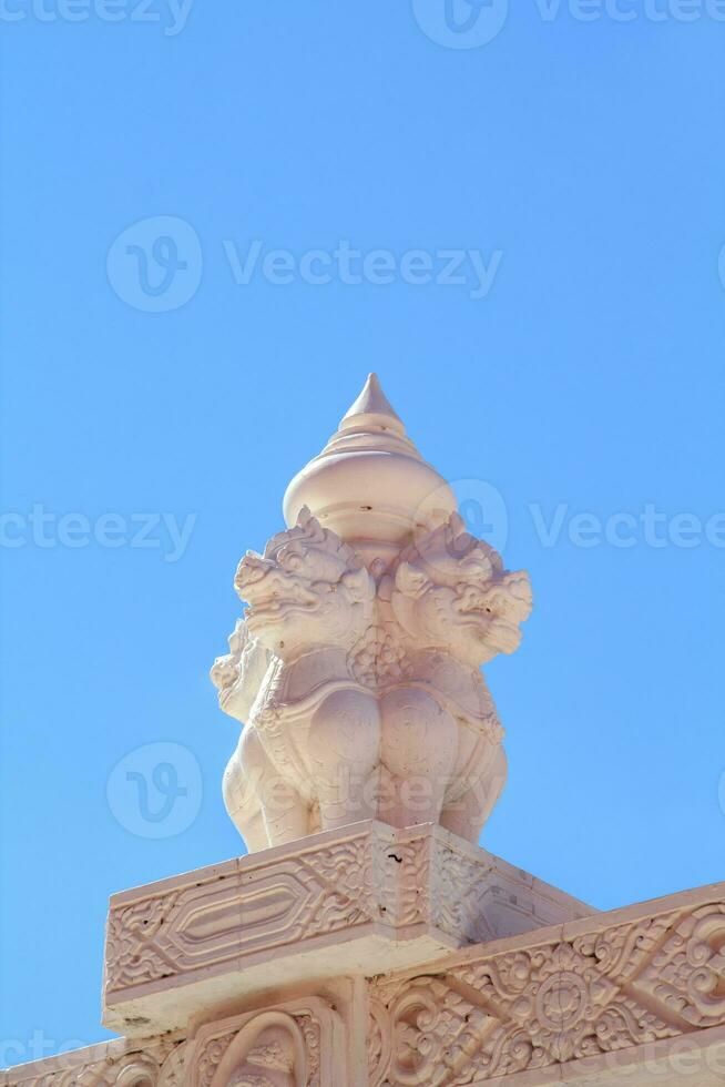 das schön und zart thailändisch Skulptur von Weiß Kirin im Stuck auf das Kirche Mauer ist ein schön Wahrzeichen und Tourist Attraktion und gegen das thailändisch Tempel Kirche Mauer und Blau Himmel Hintergrund. foto