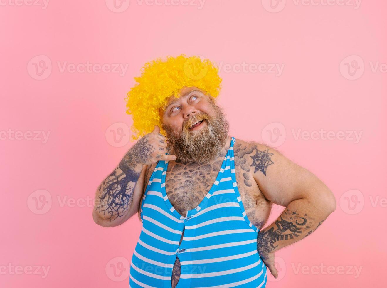 nachdenklich Mann mit Gelb Perücke und Badeanzug ist bereit zu das Sommer- foto