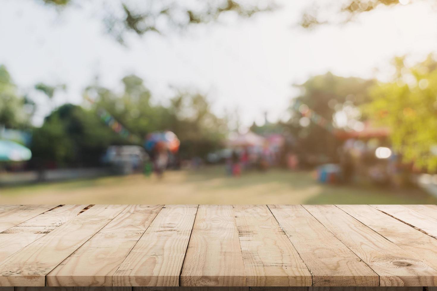 leeren Holz Tabelle und defokussiert Bokeh und verwischen Hintergrund von Garten Bäume im Sonnenlicht, Anzeige Montage zum Produkt. foto