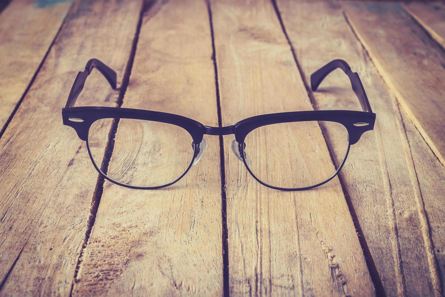 Brille Brille mit schwarz Rahmen Mode Jahrgang Stil auf Holz Schreibtisch Hintergrund foto
