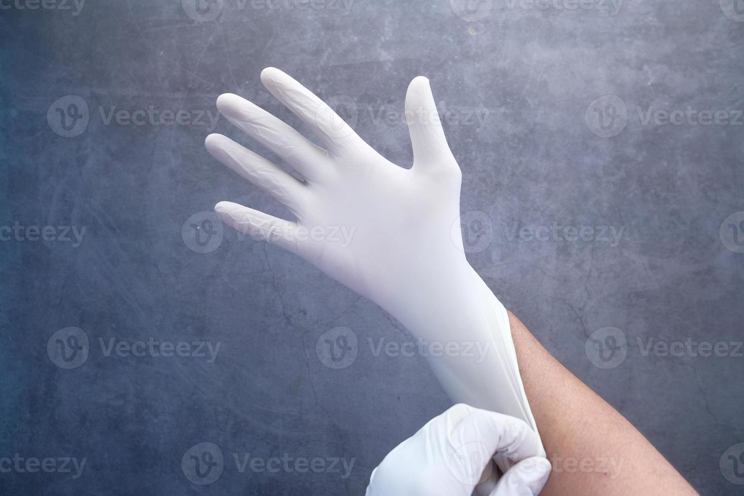 Hand einen Latexhandschuh anziehen foto