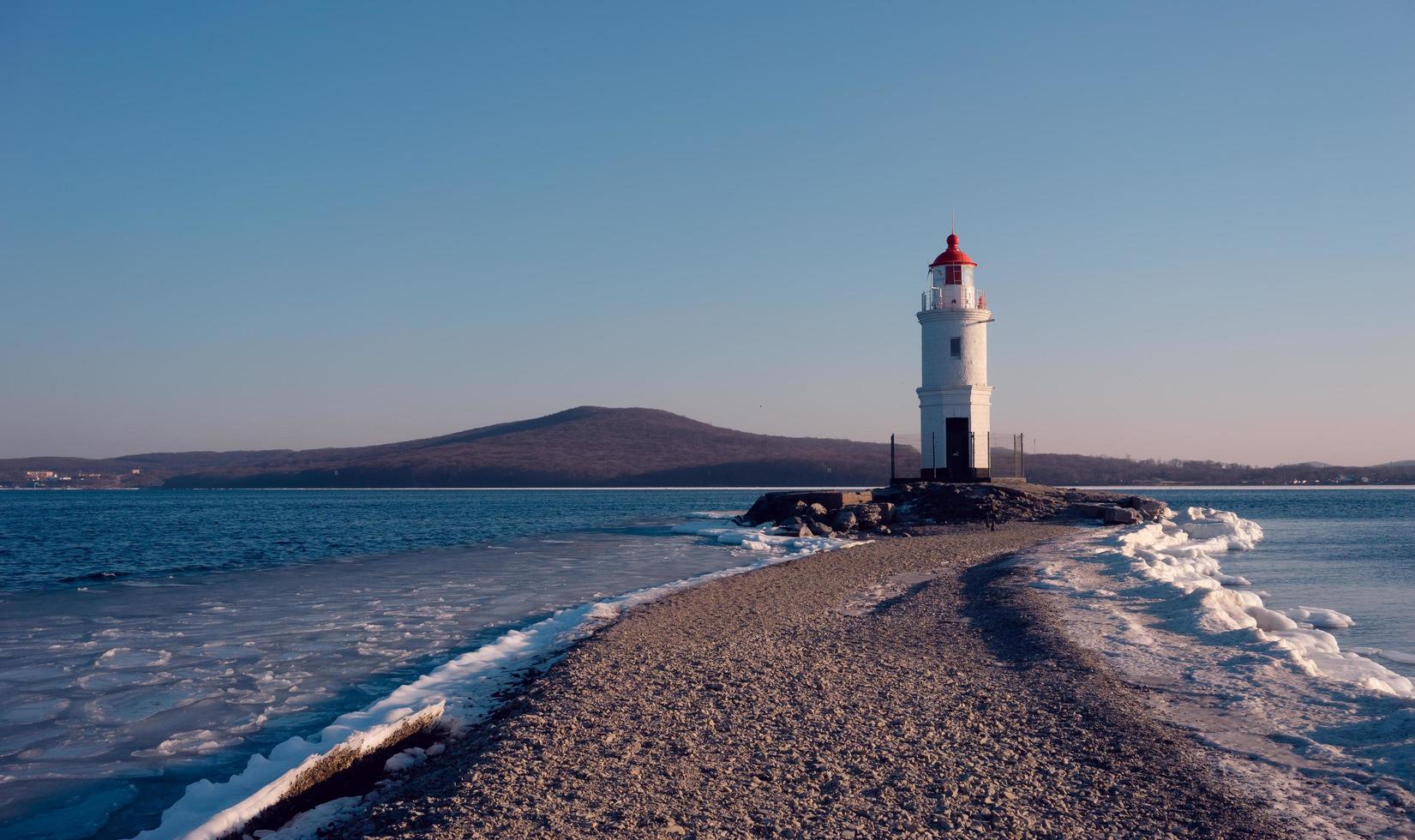 eisiger Strand der Seelandschaft und der Tokarevsky-Leuchtturm in Wladiwostok, Russland foto