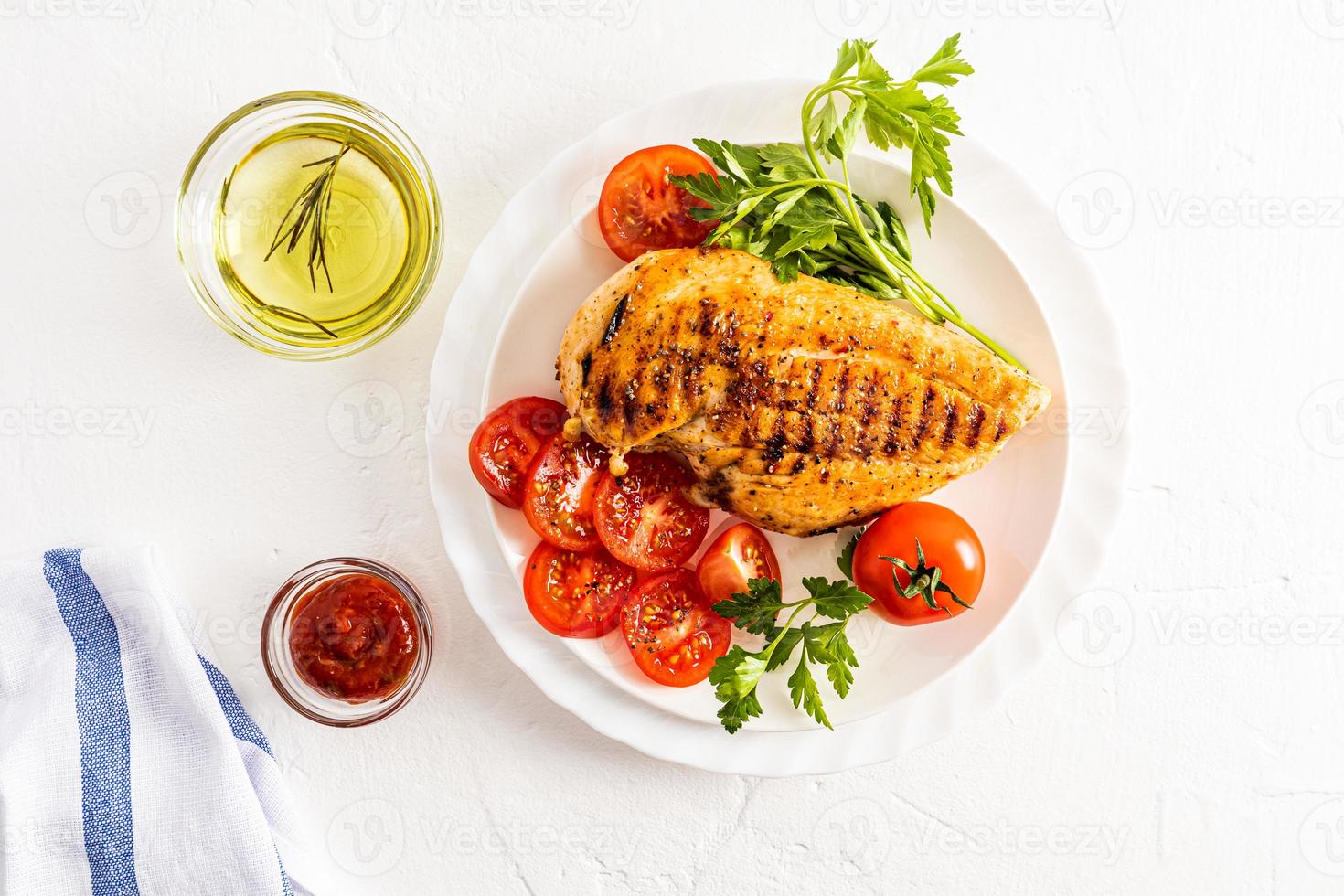 oben Aussicht von Portion Platten mit groß gegrillt Hähnchen Filets und Gemüse. Weiß Hintergrund. Schalen von Soße. Diät Lebensmittel. foto