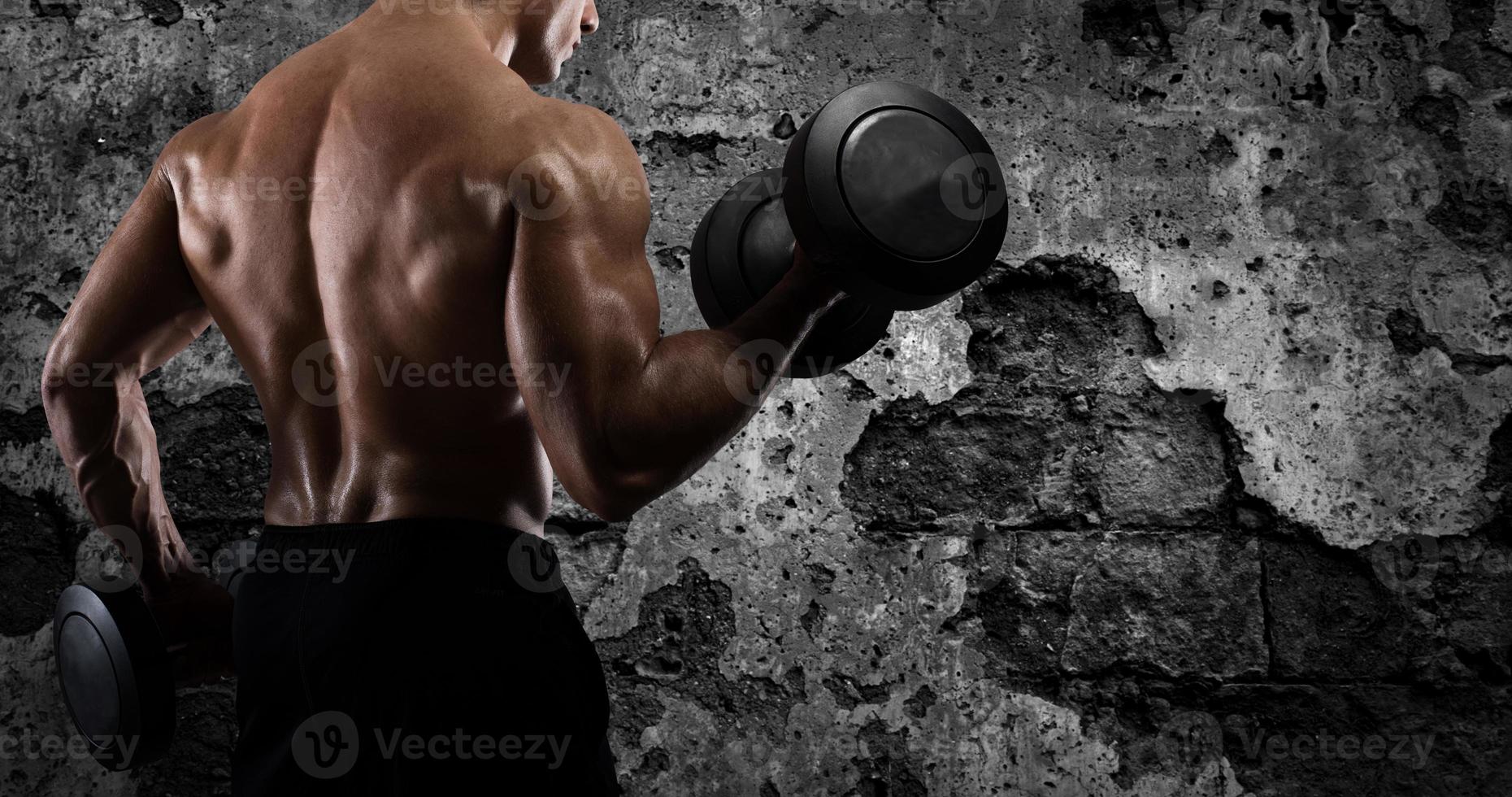 sportlich Mann Ausbildung Bizeps beim das Fitnessstudio foto