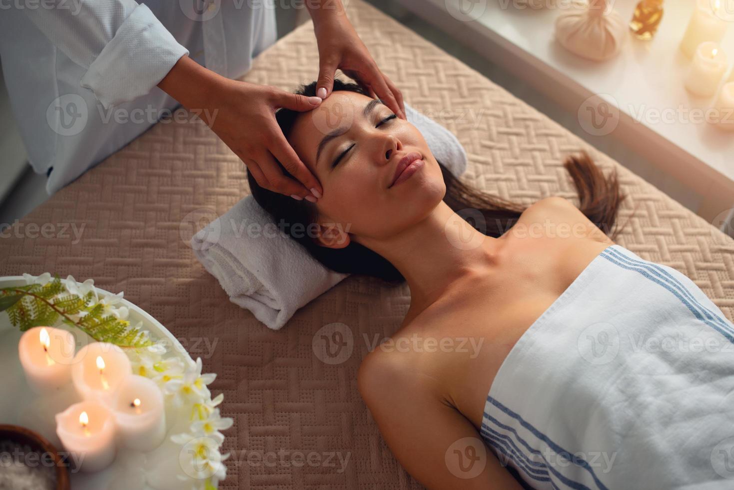 Frau entspannend mit ein Massage im ein Spa Center foto