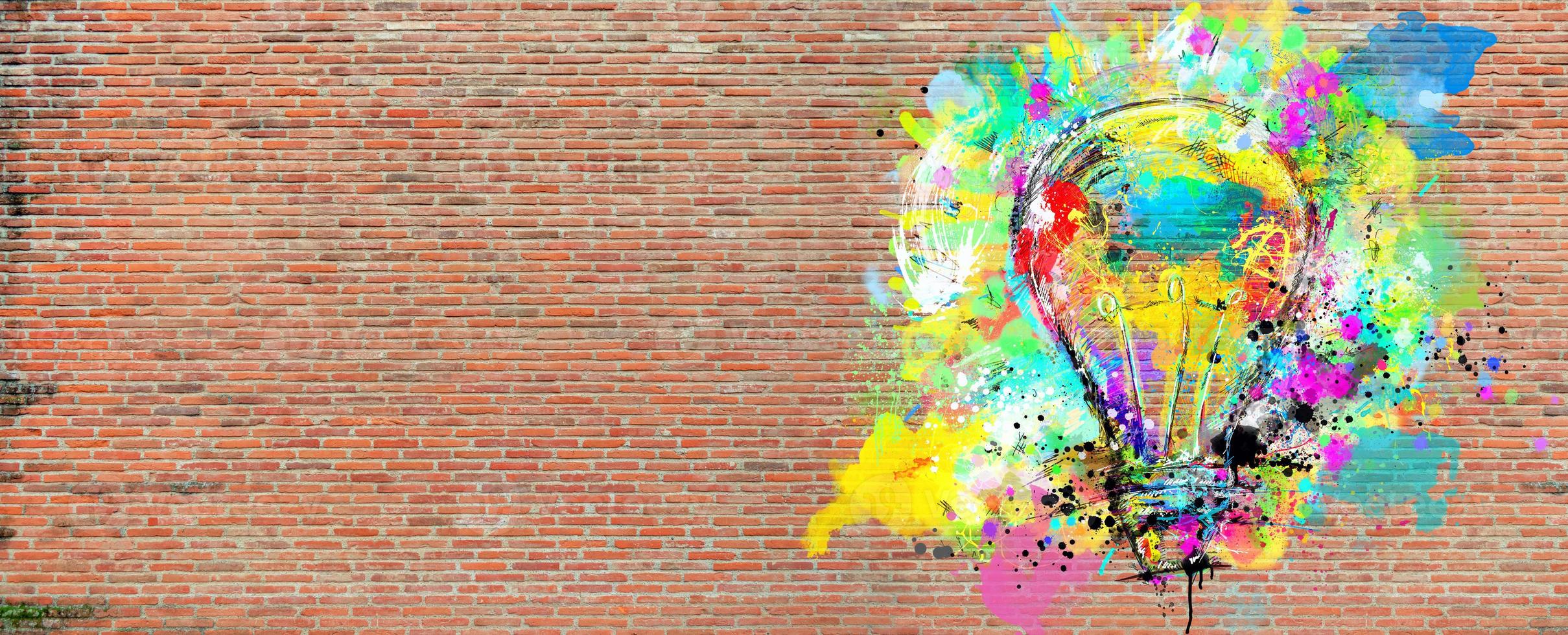 groß stilisiert Licht Birne auf ein groß Mauer von Ziegel gezeichnet mit spritzt von farbig malen. Konzept von Innovation und Kreativität Backstein foto