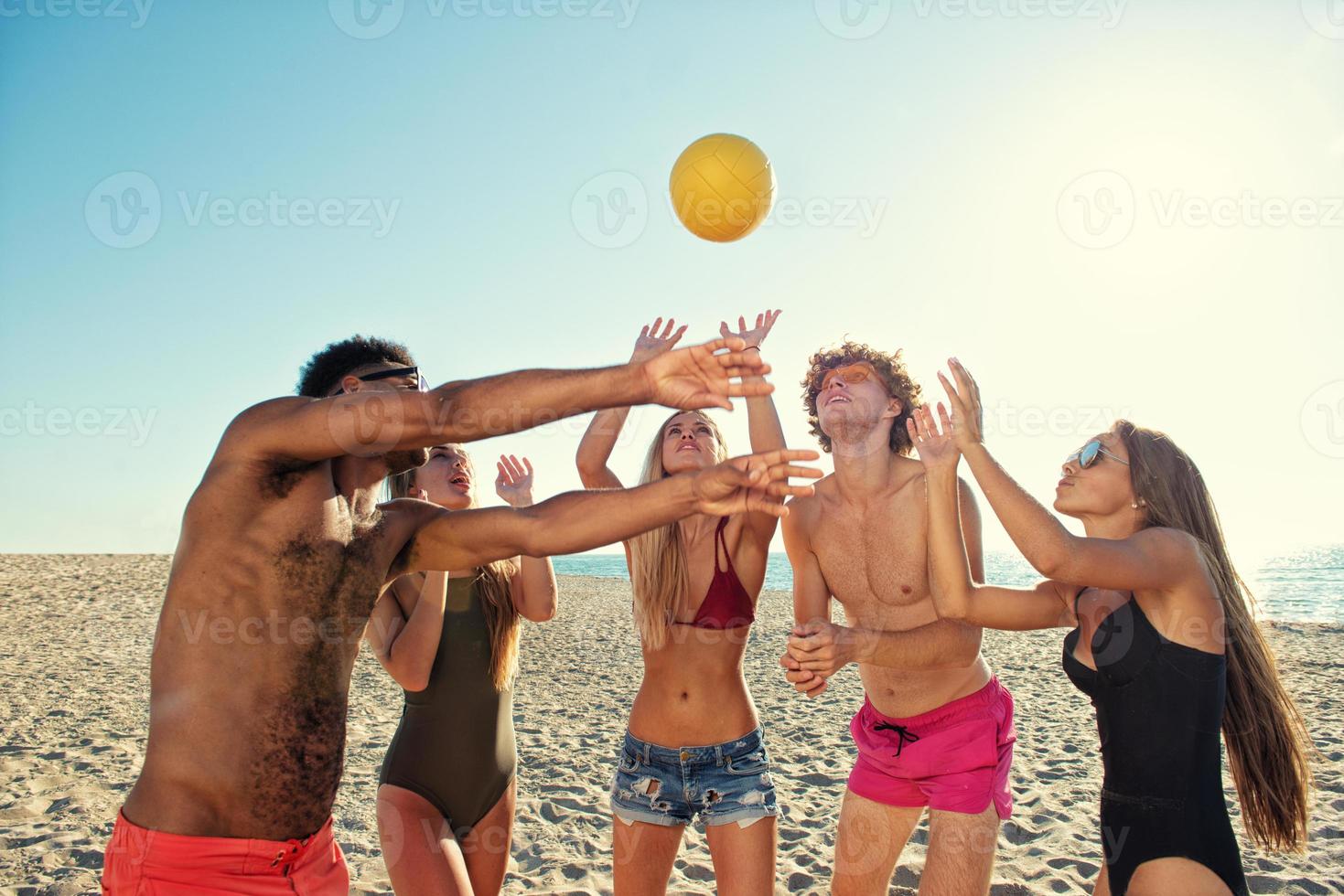 Gruppe von freunde spielen beim Strand Volley beim das Strand foto