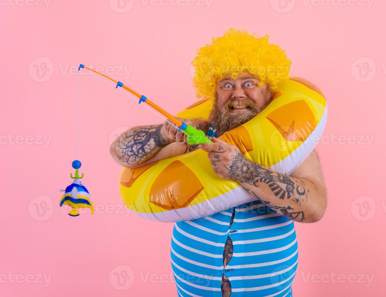 Fett glücklich Mann mit Perücke im Kopf Theaterstücke mit das Angeln Stange foto