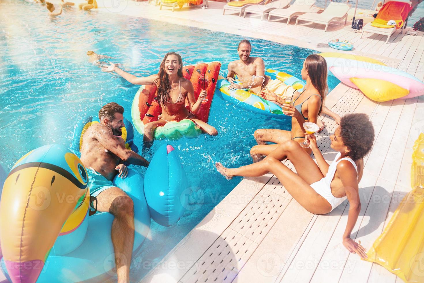 Gruppe von freunde im Badeanzug genießen im ein Schwimmen Schwimmbad foto