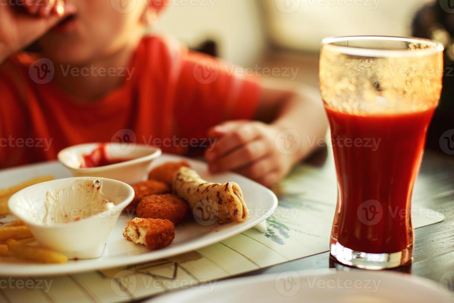 Junge Essen schnell Essen im ein Cafe. das Kind Essen Französisch Fritten mit Nuggets foto