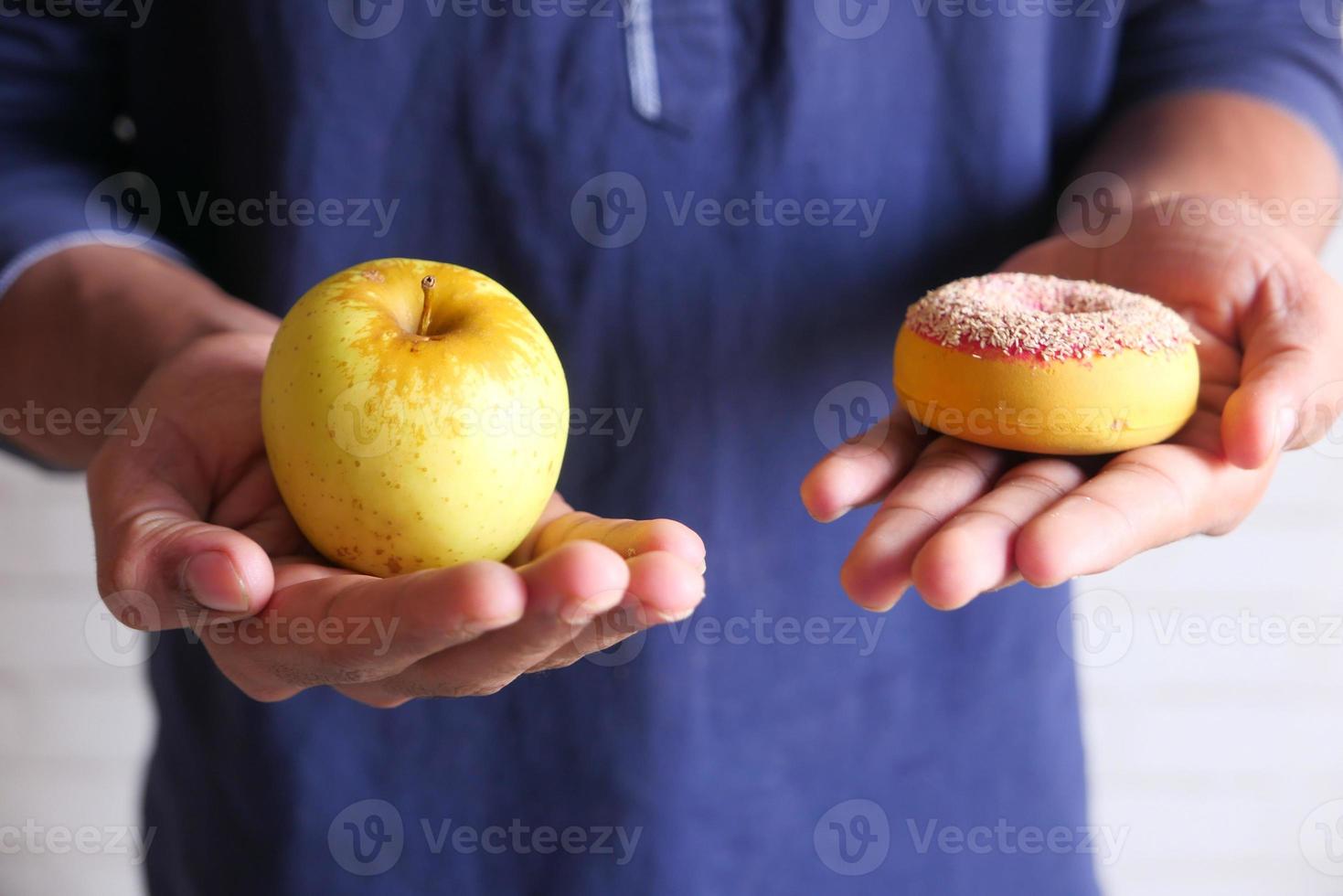 Apfel und Donut in der Hand foto