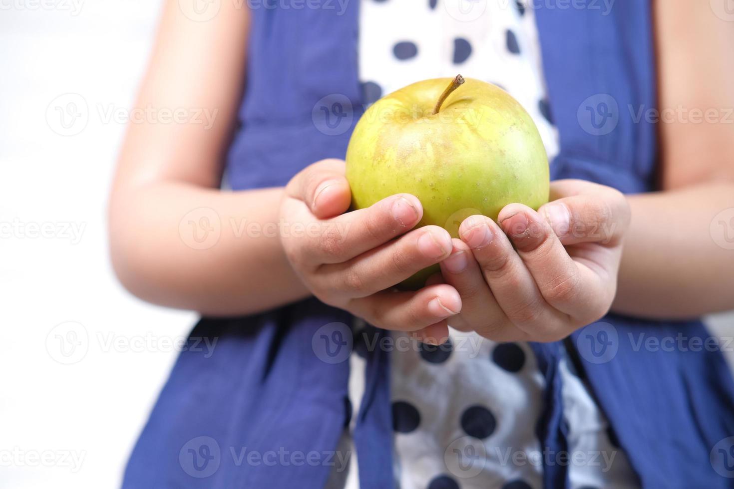 Kind hält grünen Apfel foto