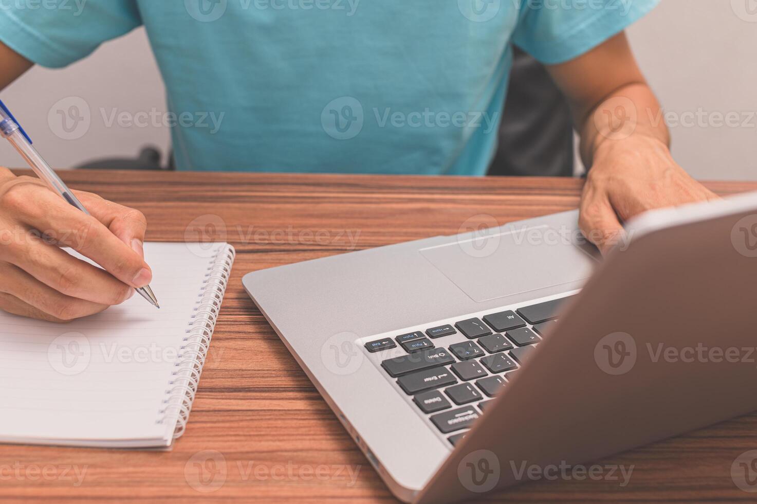 Person, die ein Buch an einem Schreibtisch schreibt foto