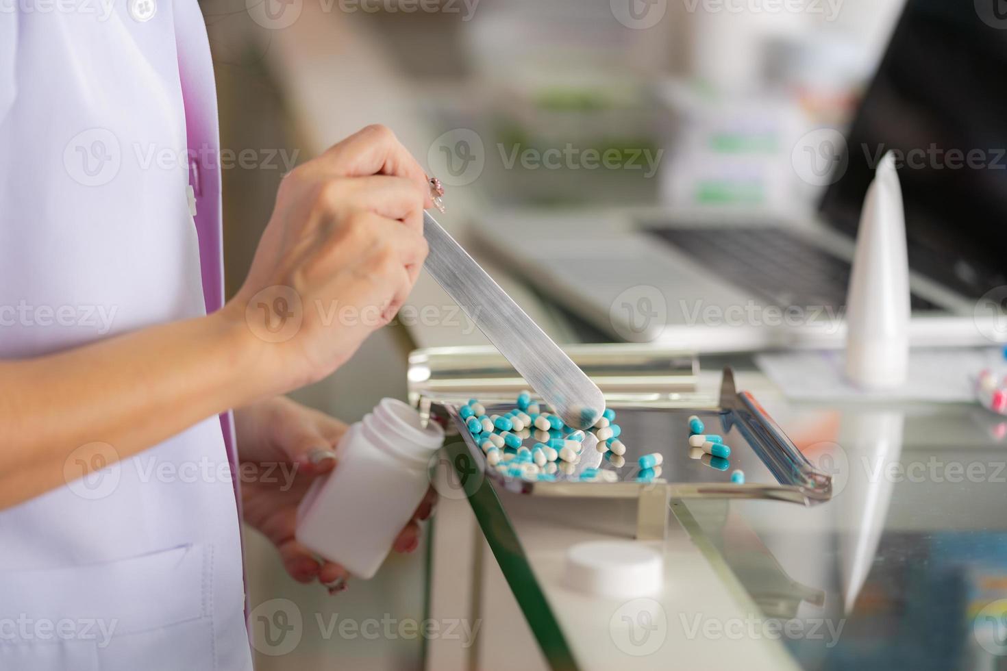 Apothekerin, die die Medizin in der Apotheke zählt foto