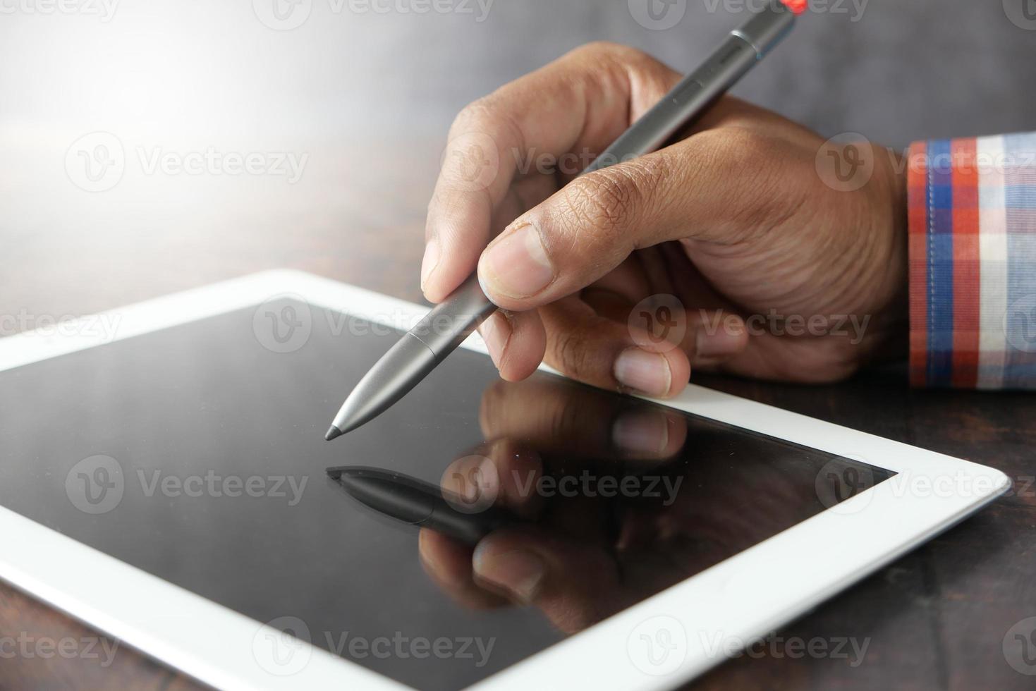 Mann mit Stift auf digitalem Tablet foto