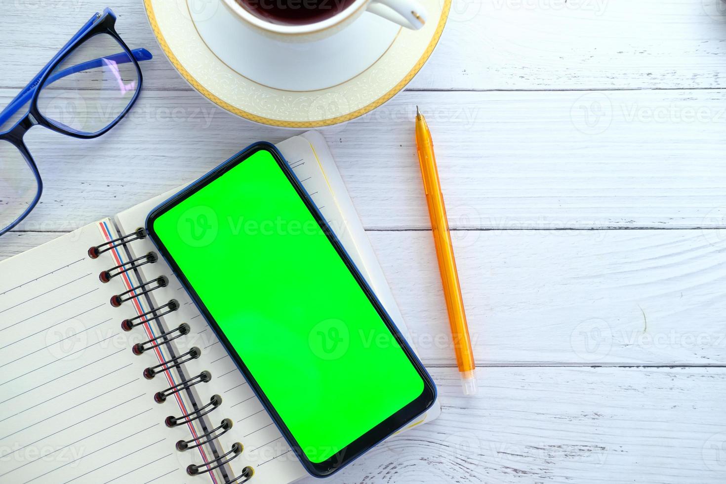Telefon mit einem grünen Bildschirm auf einem Schreibtisch foto