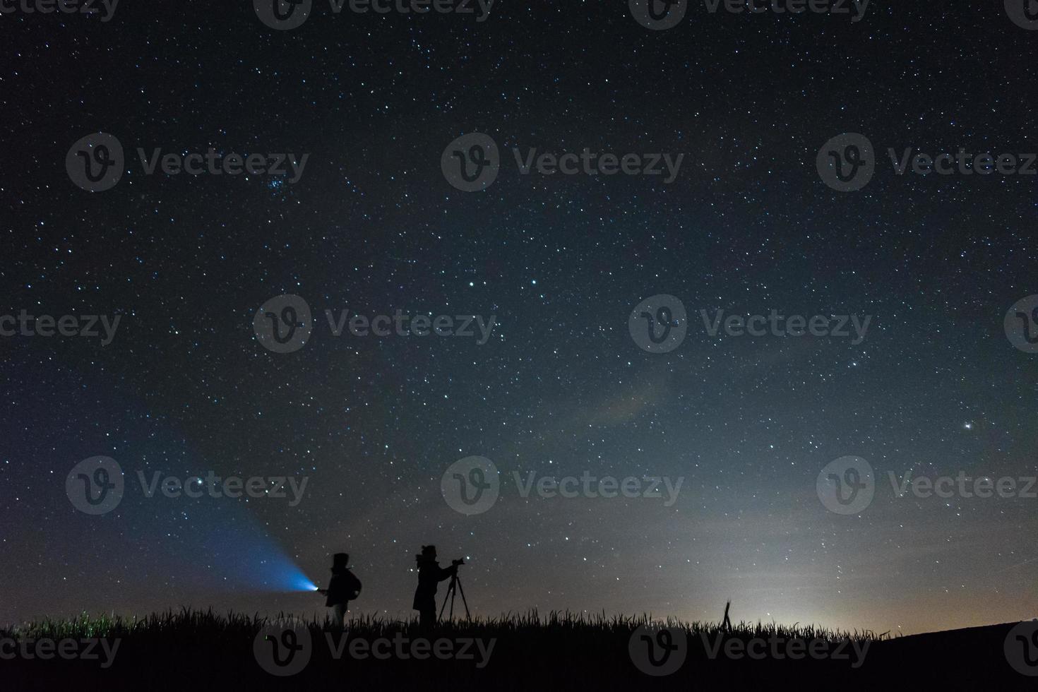 Silhouette Fotografen mit einem Himmel voller Sterne Hintergrund in der Nacht foto