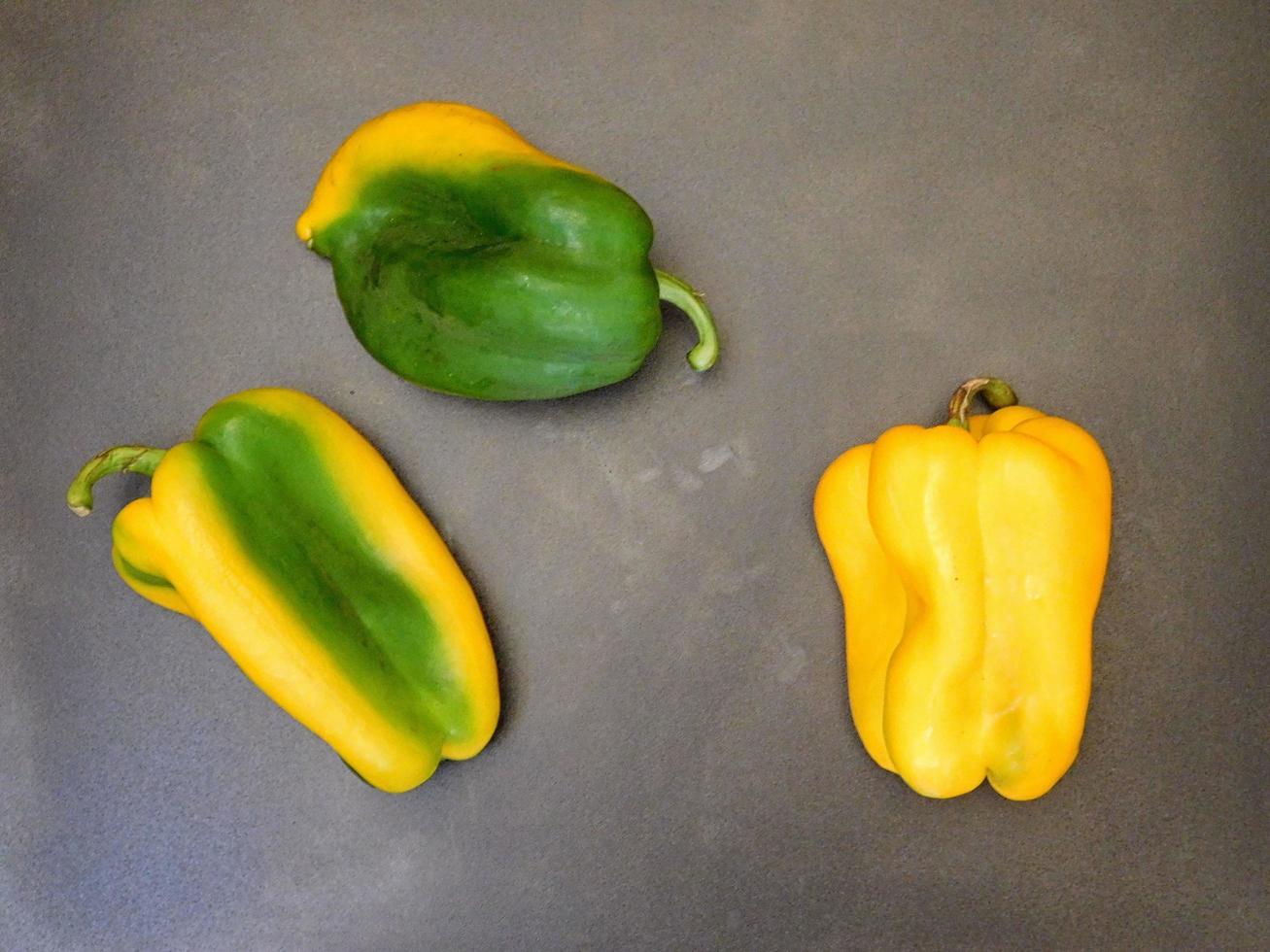 grüne und gelbe Paprika auf einem hölzernen Tischhintergrund foto