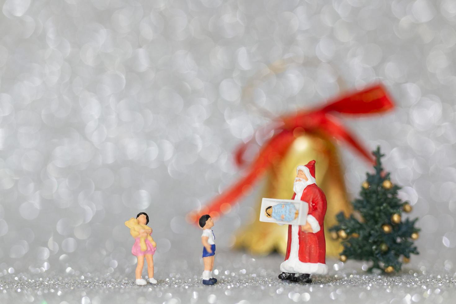 glückliche Miniaturfamilie, die Weihnachten, Weihnachten und ein frohes neues Jahrkonzept feiert foto