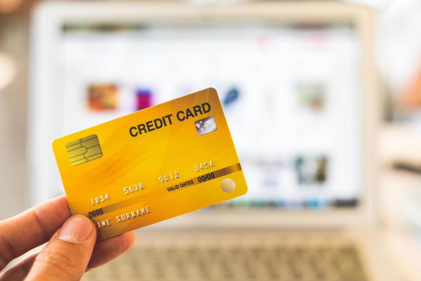 Hände, die eine Kreditkarte halten und einen Laptop verwenden, Online-Einkaufskonzept foto