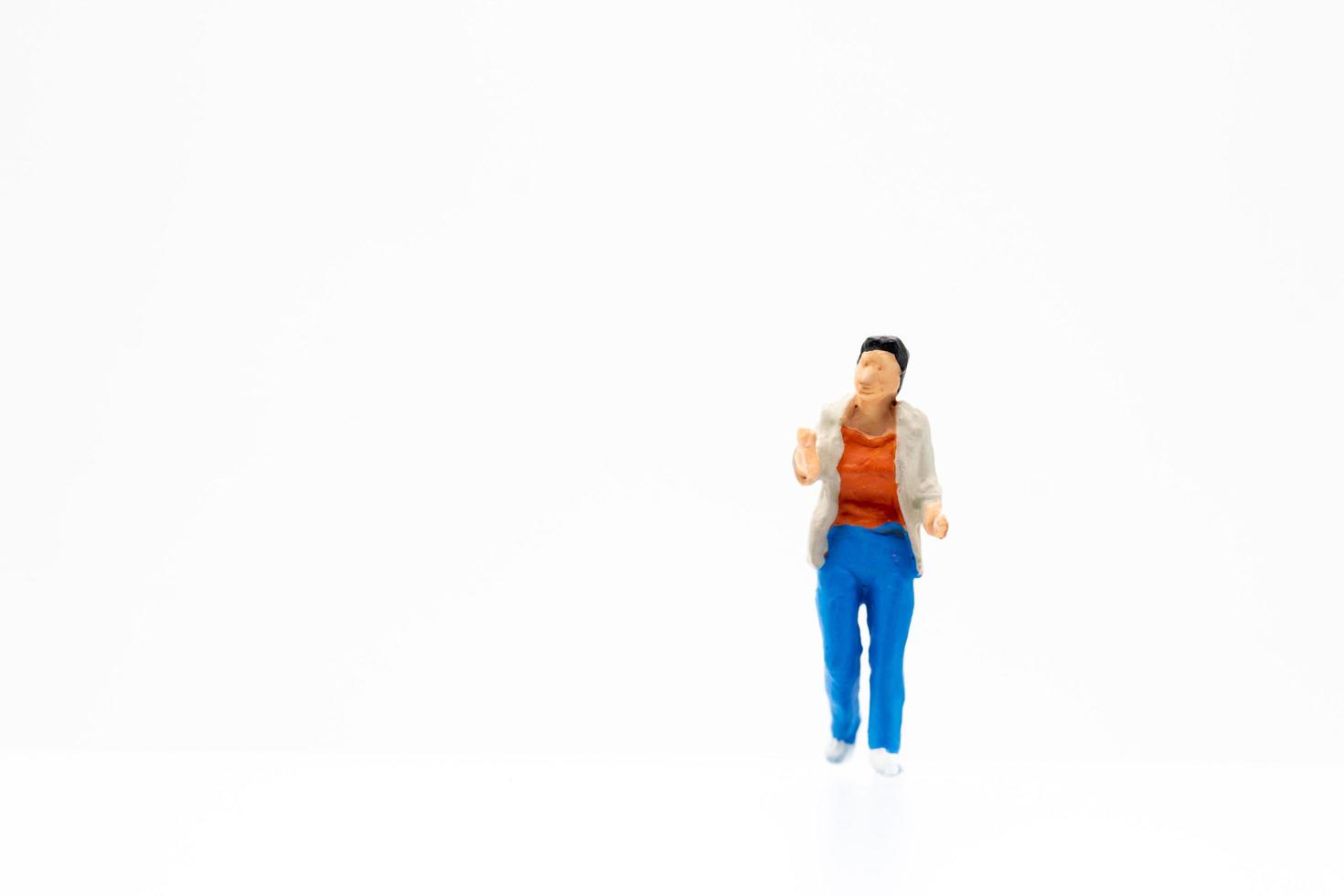 eine Miniaturperson, die auf einem weißen Hintergrund steht foto