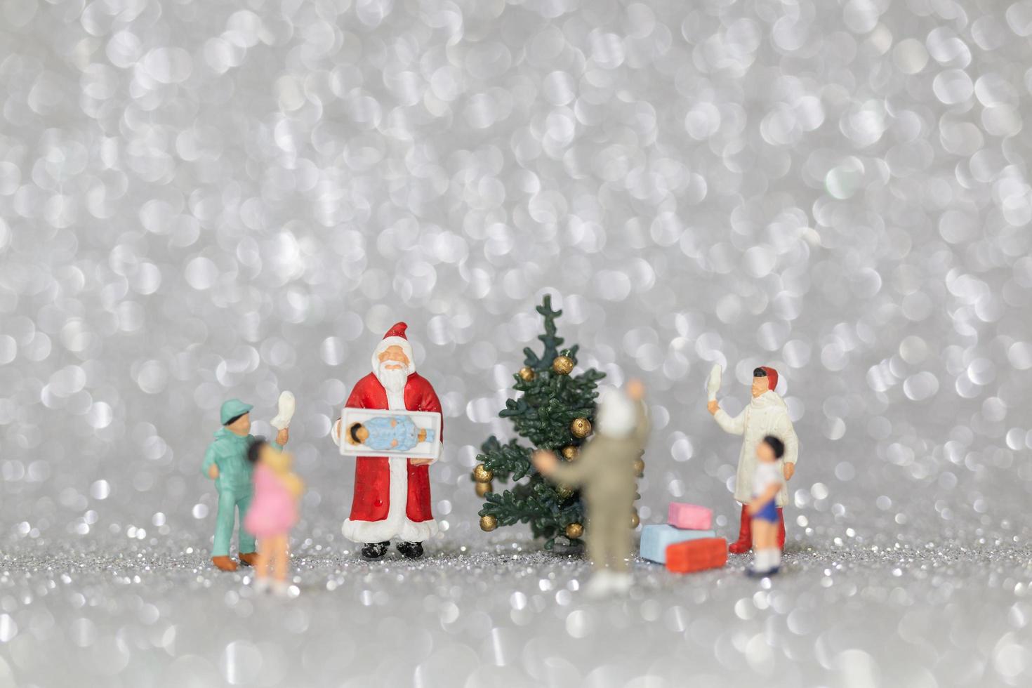 glückliche Miniaturfamilie, die Weihnachten, Weihnachten und ein frohes neues Jahrkonzept feiert foto
