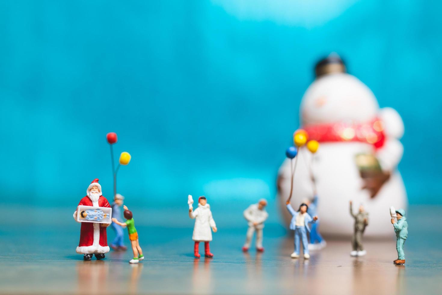 glückliche Miniaturfamilie, die Weihnachten, Weihnachten und ein frohes neues Jahrkonzept feiert foto