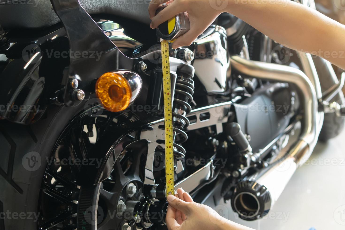 Mechaniker mit Band messen einstellen oben Suspension durchhängen Kompression und Rebound auf Motorrad beim Garage, Reparatur und Instandhaltung Motorrad Konzept .selektiv Fokus foto