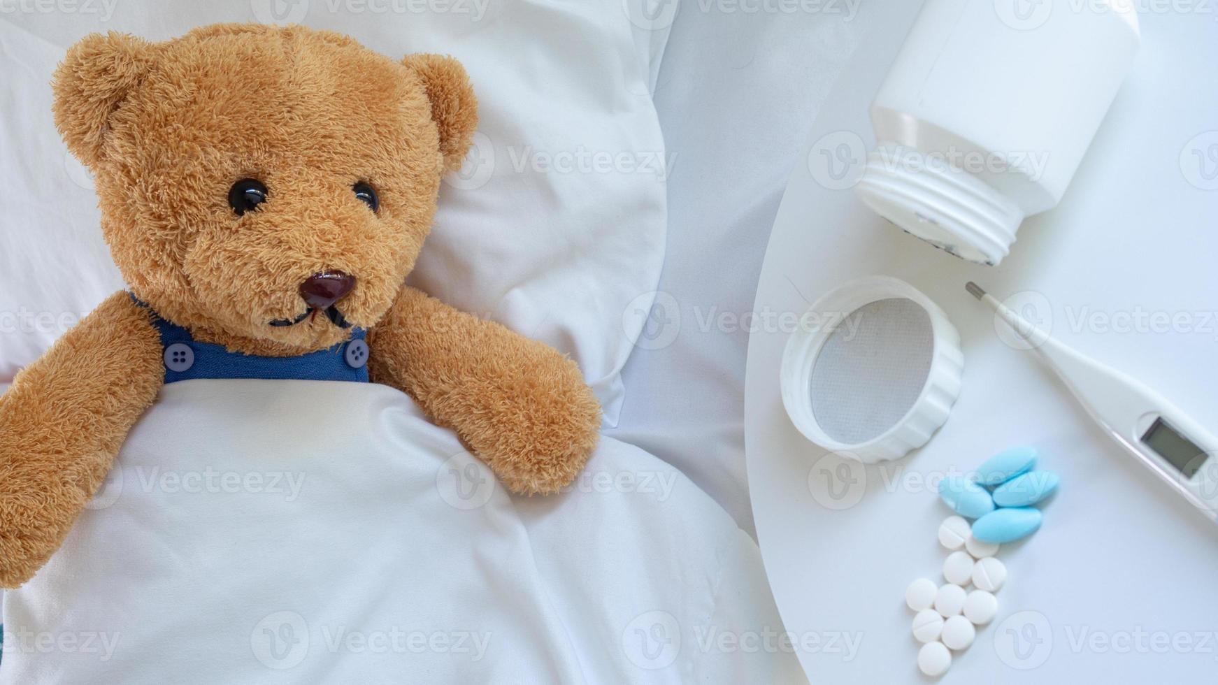 das traurig Teddy Bär hätten ein Kopfschmerzen und Fieber, Lügen krank im das Bett. foto
