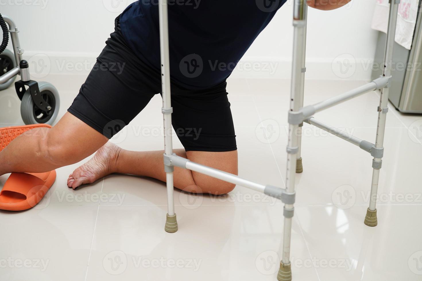 Verletzung der asiatischen Frau durch Herunterfallen auf rutschigen Oberflächen mit Walker zu Hause. foto