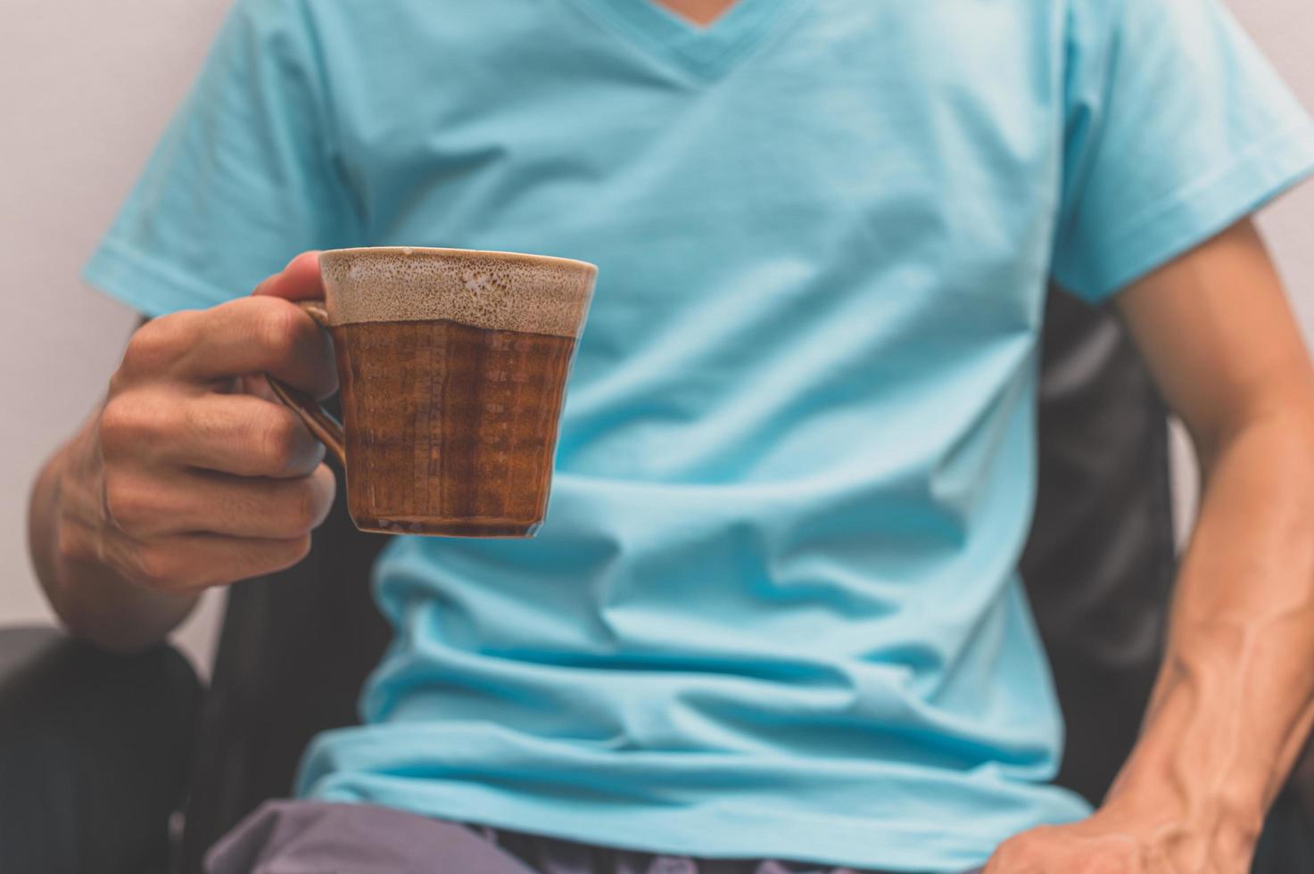 Mann hält eine Tasse Kaffee foto