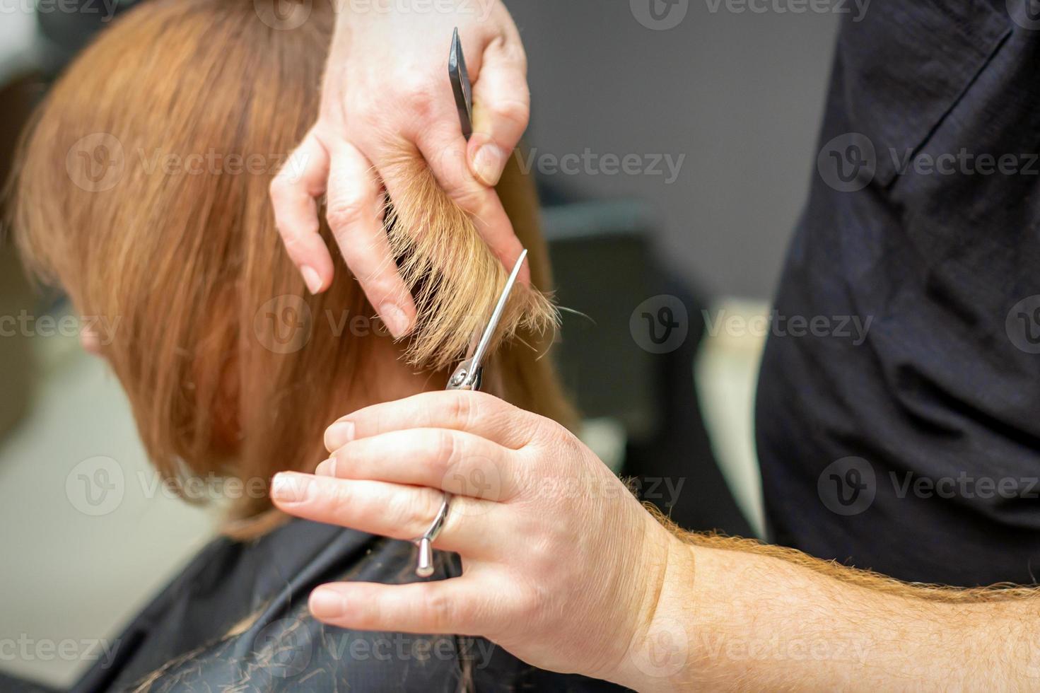 Friseur schneidet Haar zu jung Frau foto