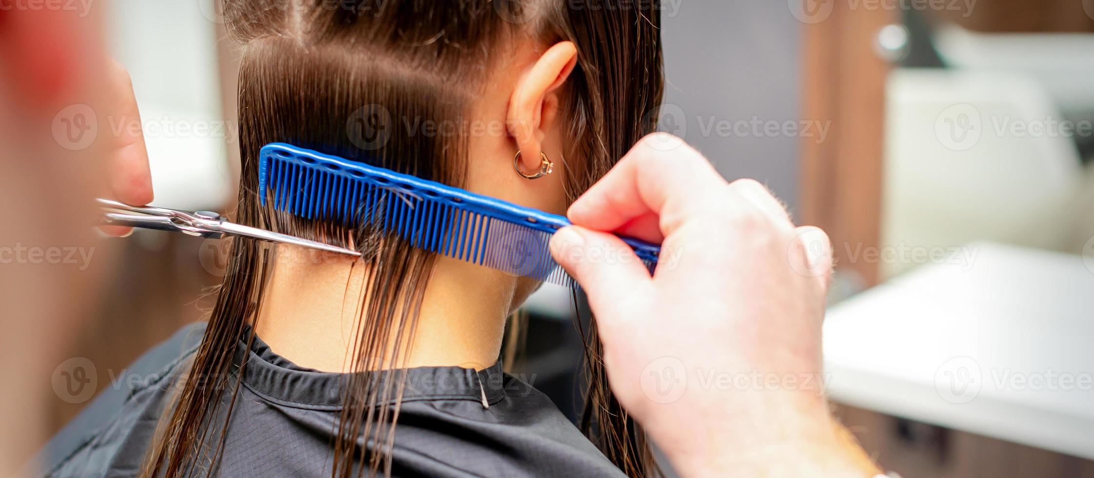 Friseur schneidet aus lange Haar von Frau foto