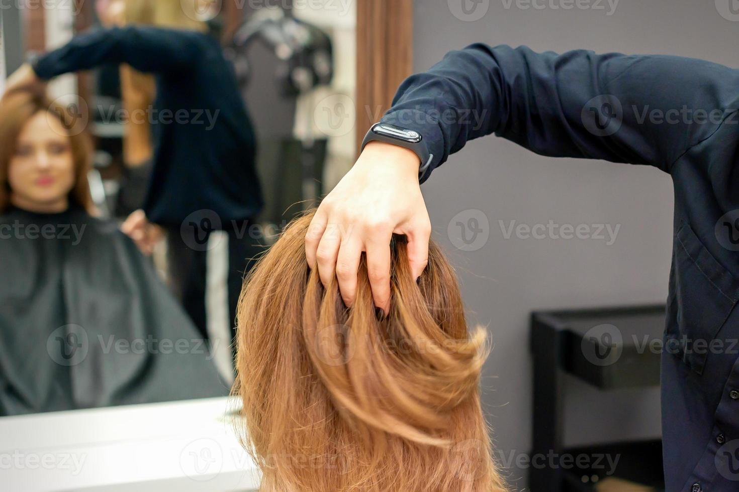 Friseur prüft Frisur von Frau foto