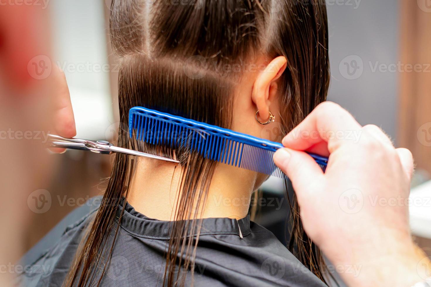 Friseur schneidet aus lange Haar von Frau foto