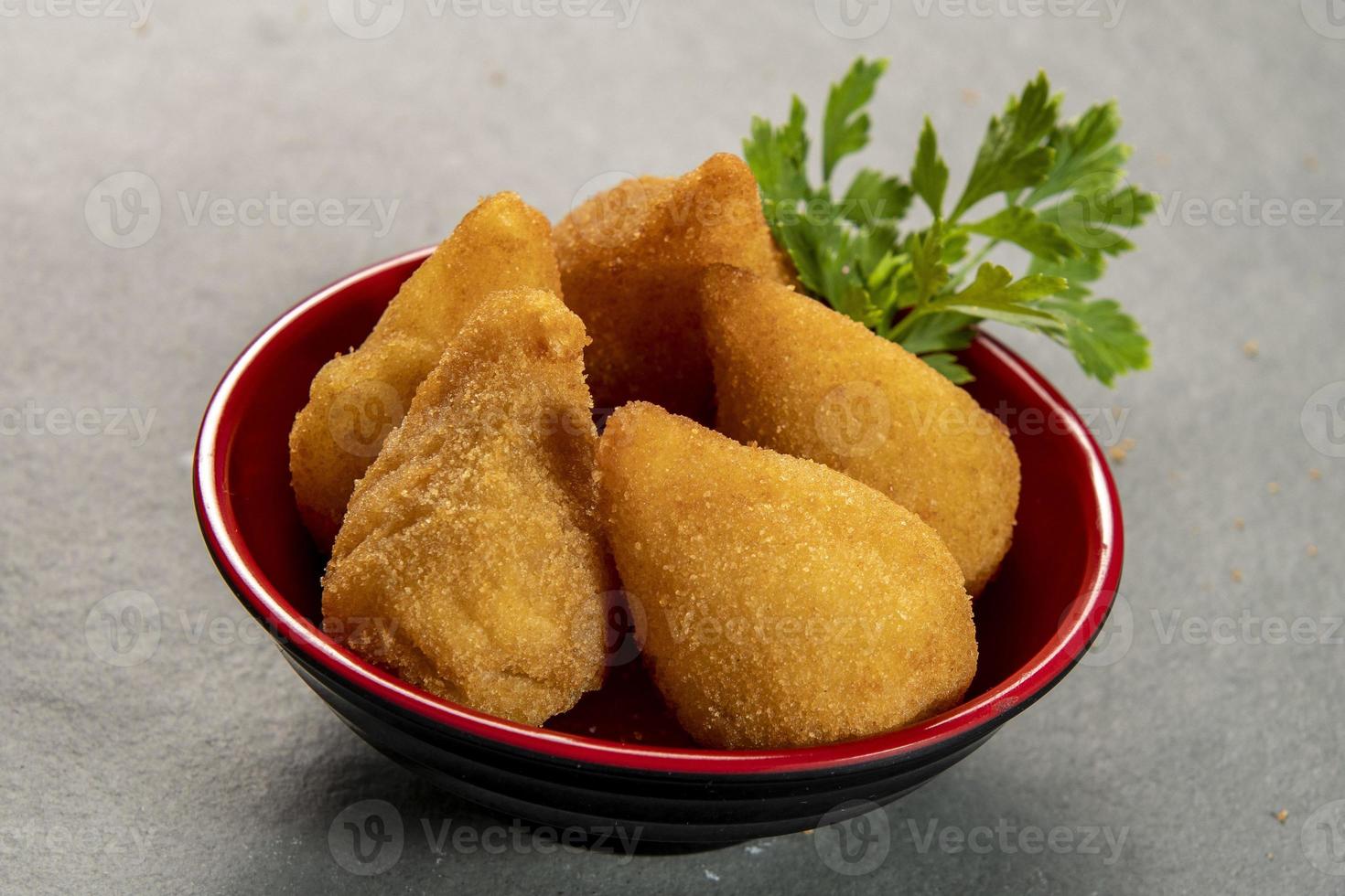 traditionell gebraten Coxinha im Teller auf Schiefer Hintergrund, Beliebt Brasilianer Snack foto