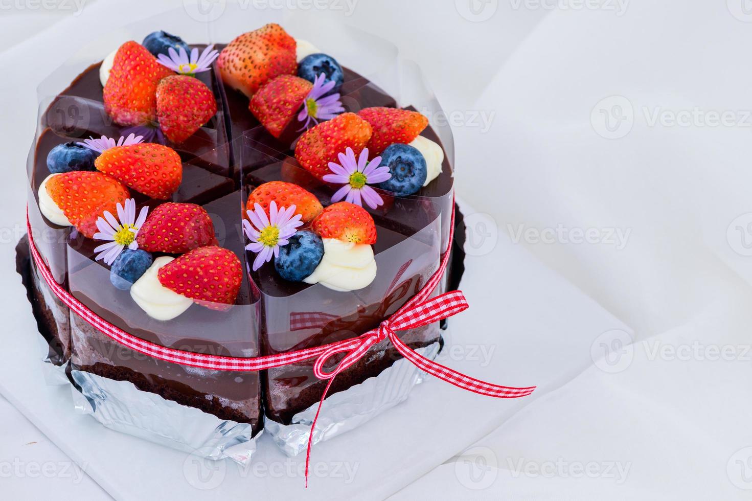 Schokolade Kuchen dekoriert mit frisch Erdbeere und Blaubeeren auf Spitze, foto