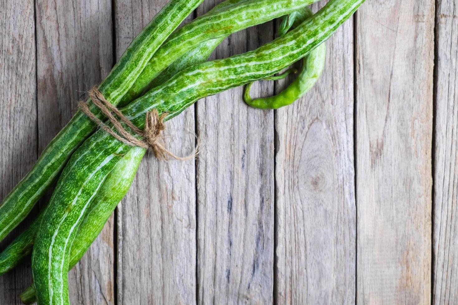 Zucchini mit Schnur auf einem hölzernen Hintergrund gebündelt foto