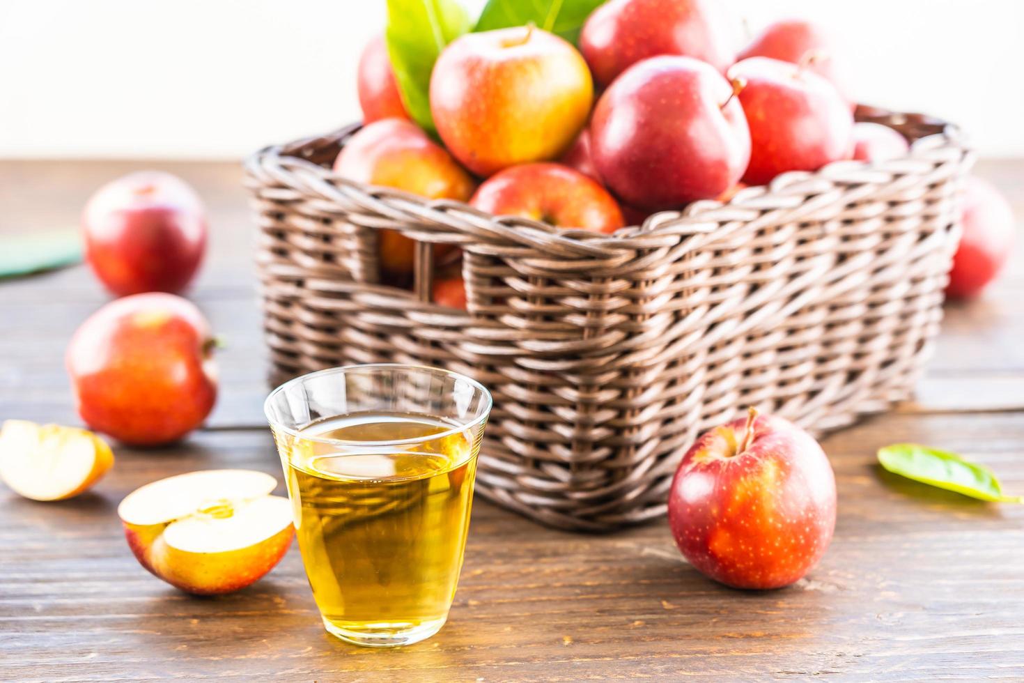 Apfelsaft in Glas und Äpfel im Korb foto