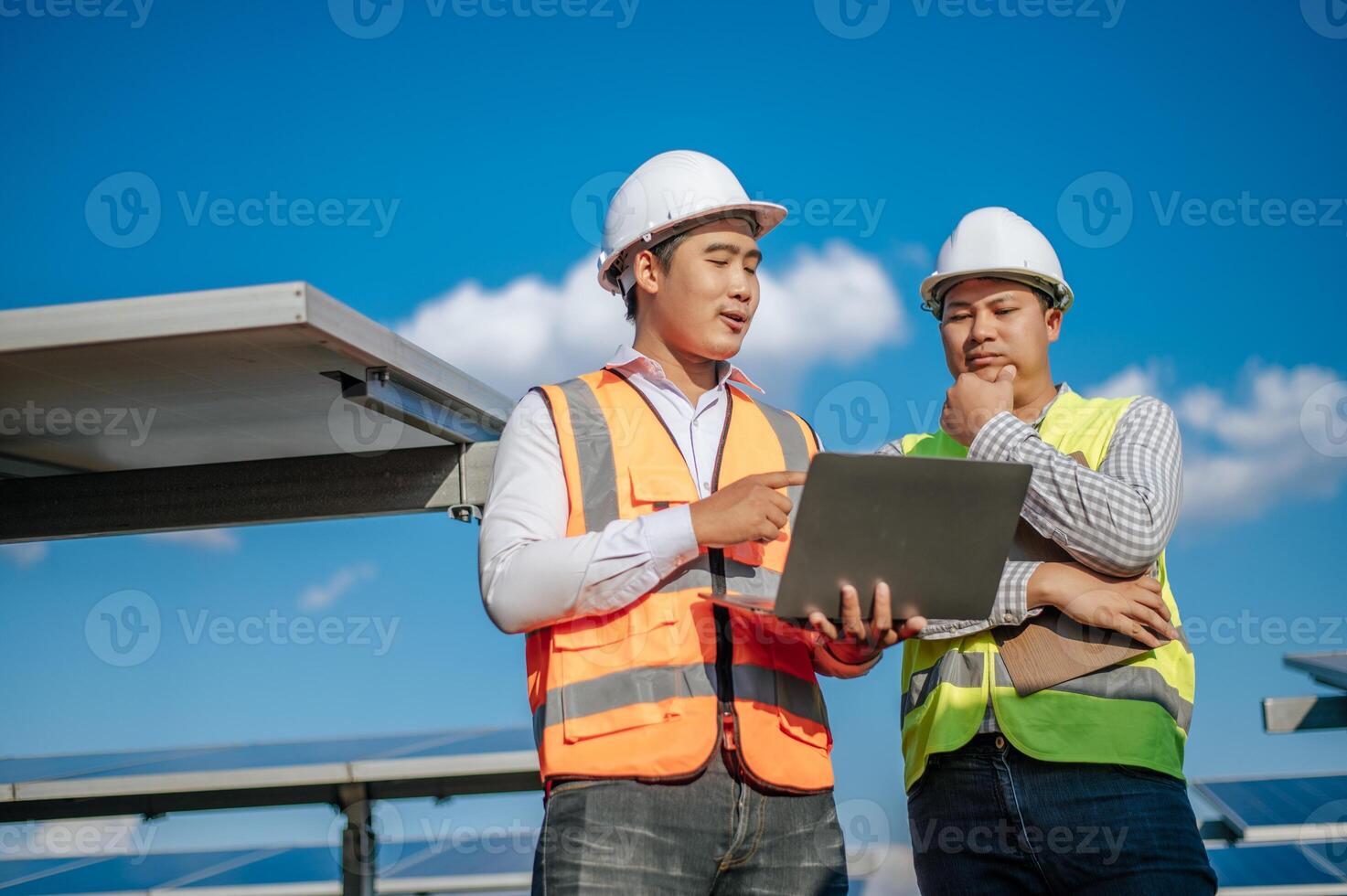 Junger Techniker, der im Solarpark am Laptop arbeitet foto