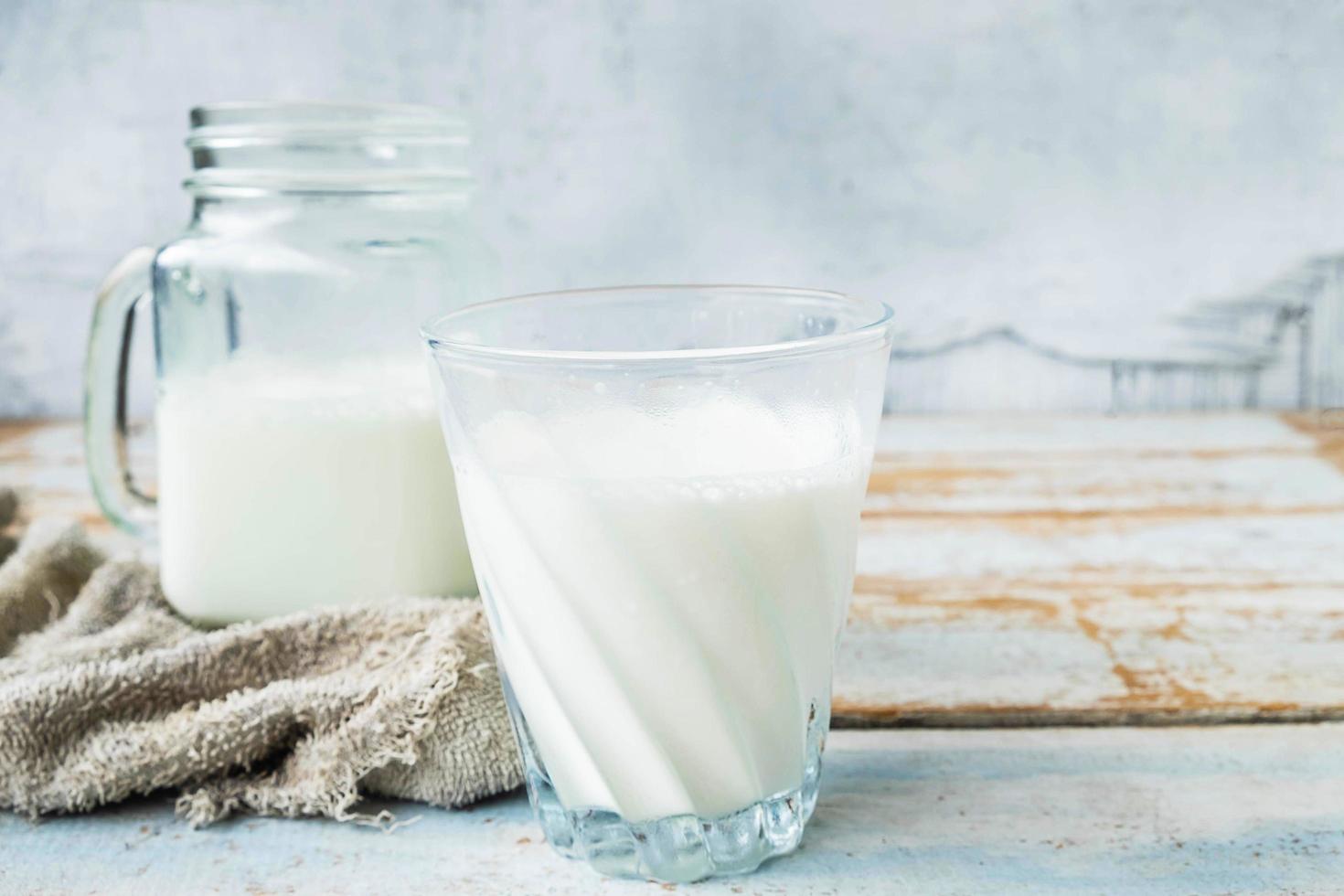 Milch in Gläsern auf einem Holztisch foto