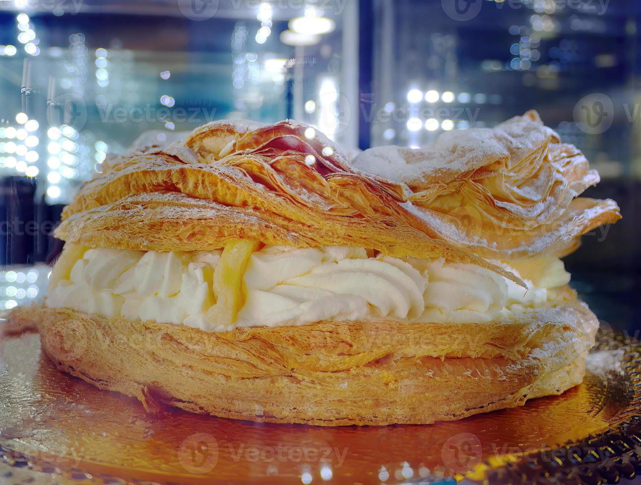 klassisch Dessert Riese Ringe von paris-brest Choux Gebäck, Creme Musselin, gefüllt mit Sanft Käse Sahne pulverisiert mit Zucker Pulver, Pudding Kuchen im dunkel Hintergrund foto