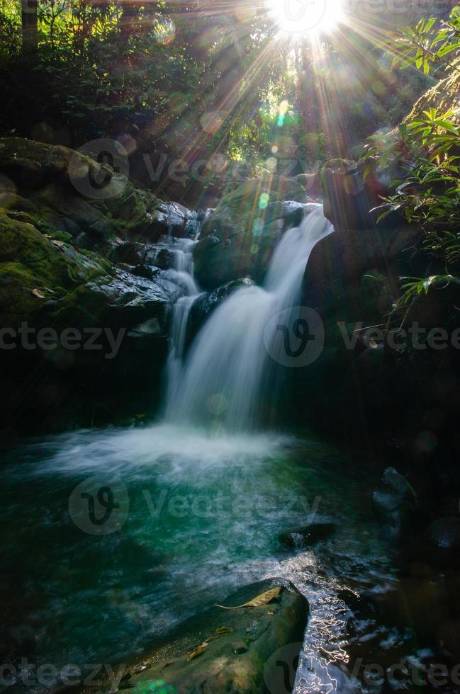 glatt Wasserfall Smaragd Farbe mit Sonnenstrahl foto