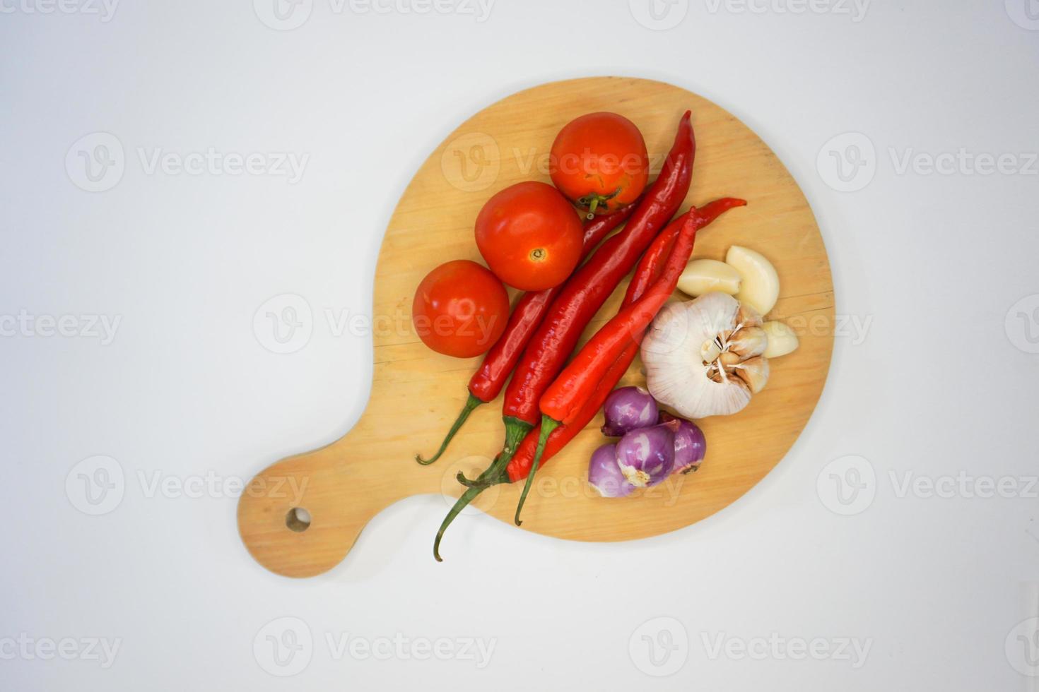 Knoblauch, Chili, rot Zwiebel und Tomaten auf ein hölzern Platte, oben Winkel Schuss. foto