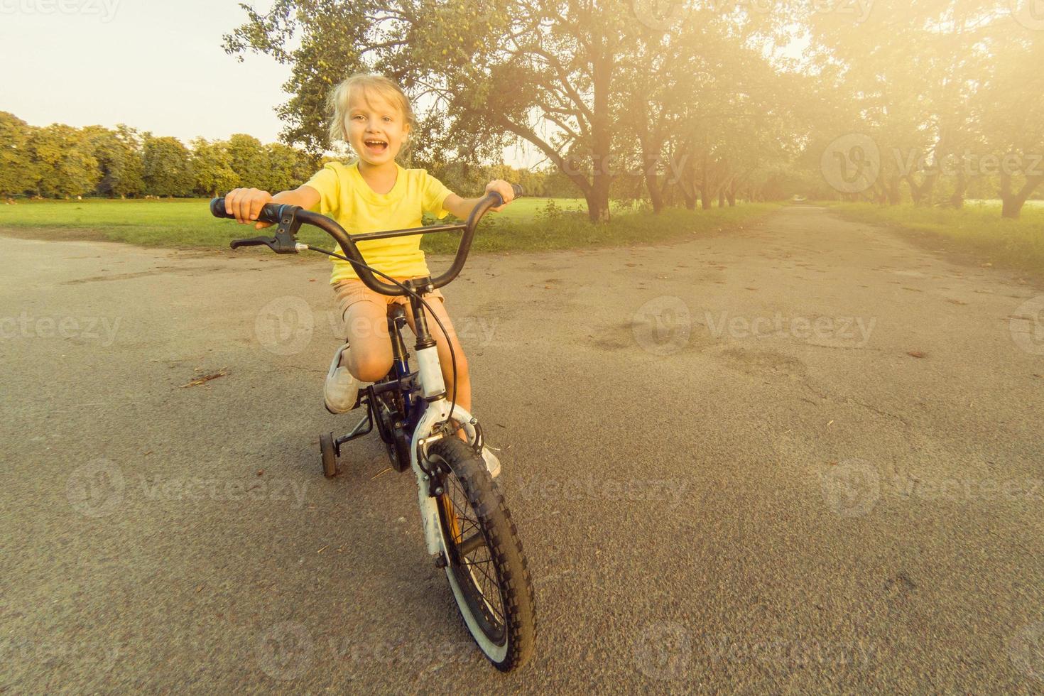 wenig Mädchen lernt zu behalten Balance während Reiten ein Fahrrad foto