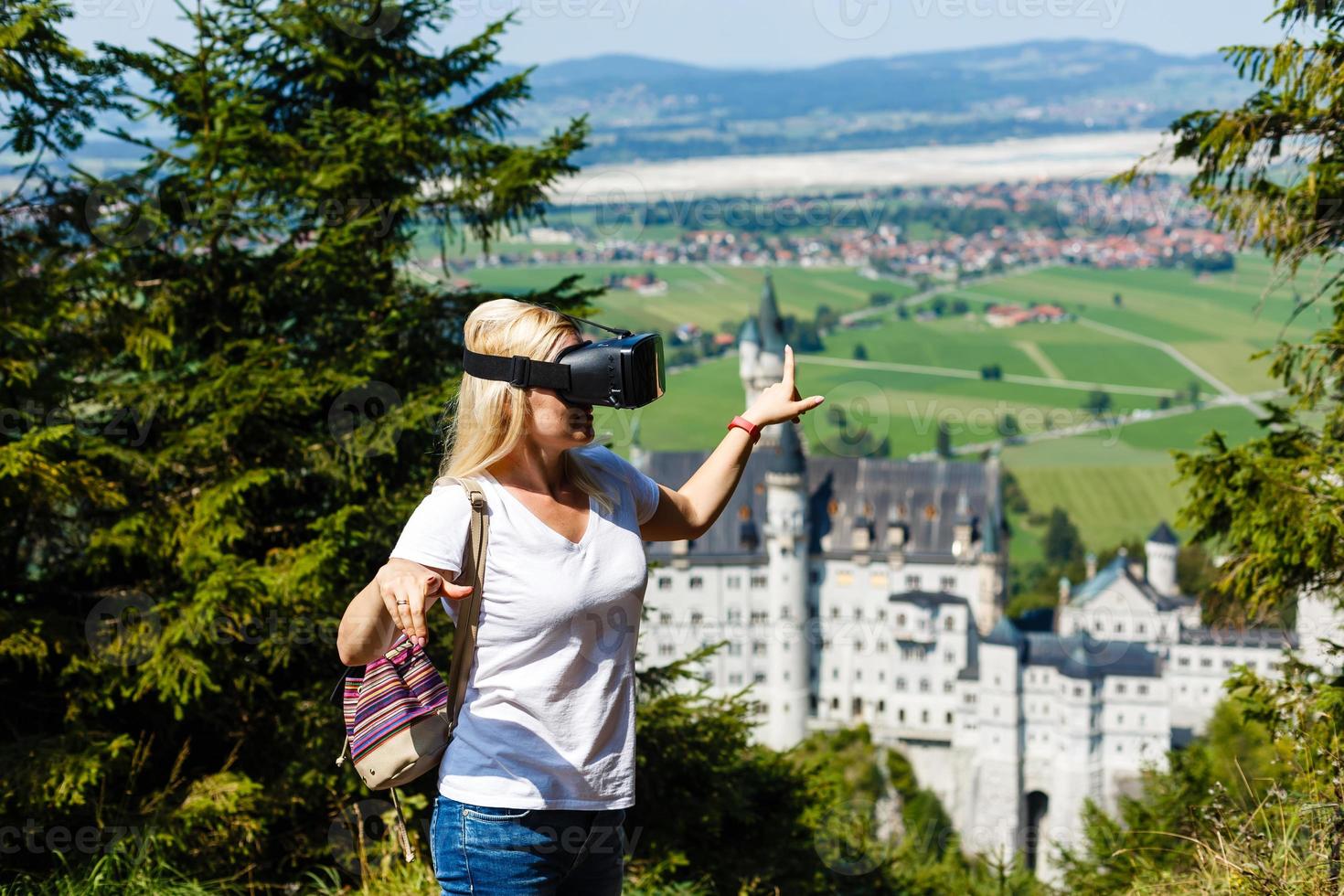 ein Reisender mit virtuell Wirklichkeit Brille. das Konzept von virtuell Reise um das Welt. im das Hintergrund Schloss Neuschwanstein. Zukunft Technologie Konzept. foto