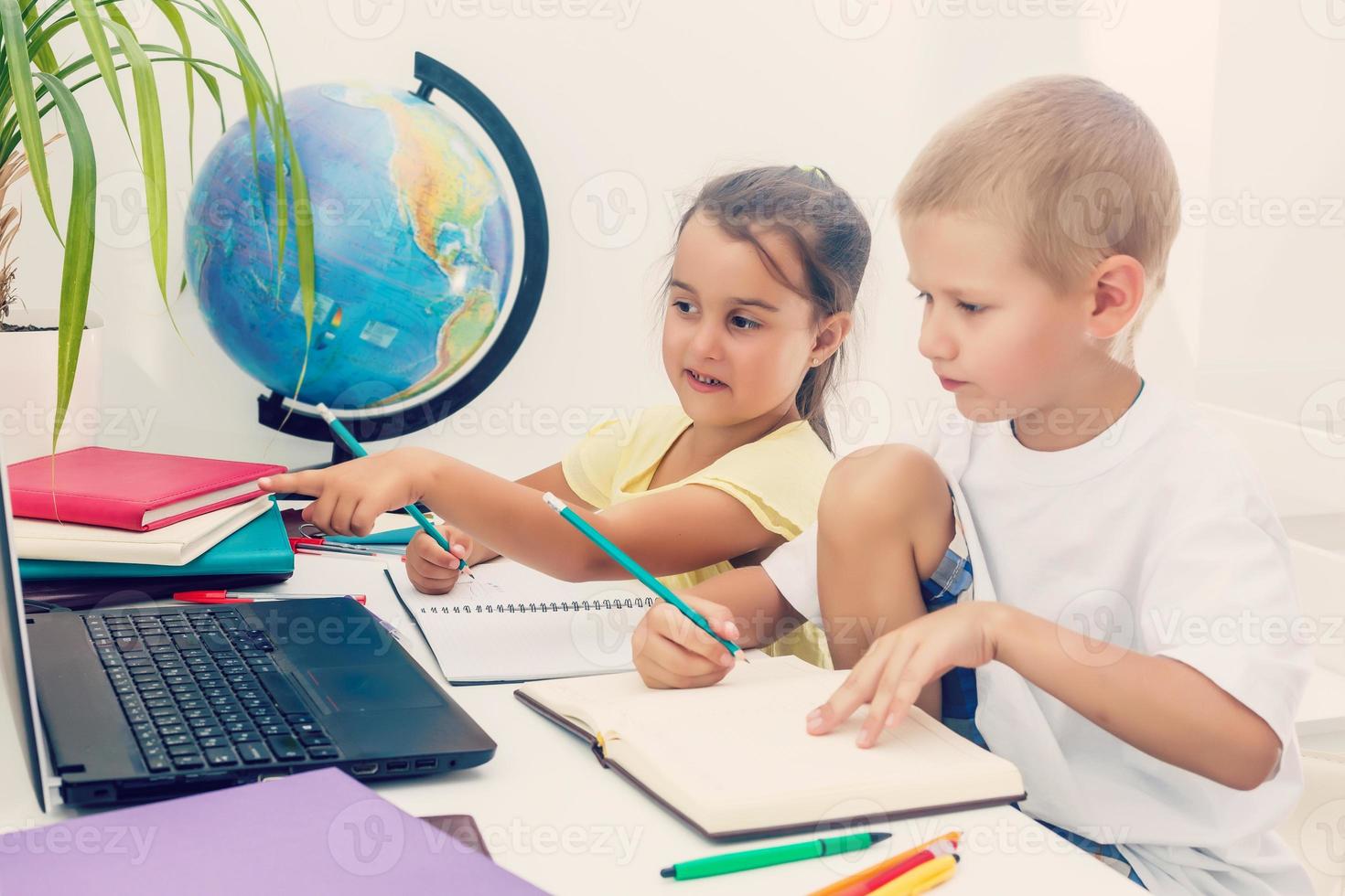 Junge und Mädchen mit ein Laptop beim Schule. foto