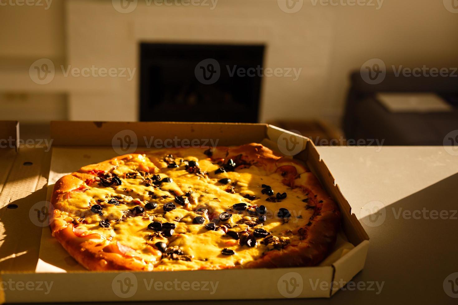 Karton Box mit köstlich Pizza auf Tabelle foto