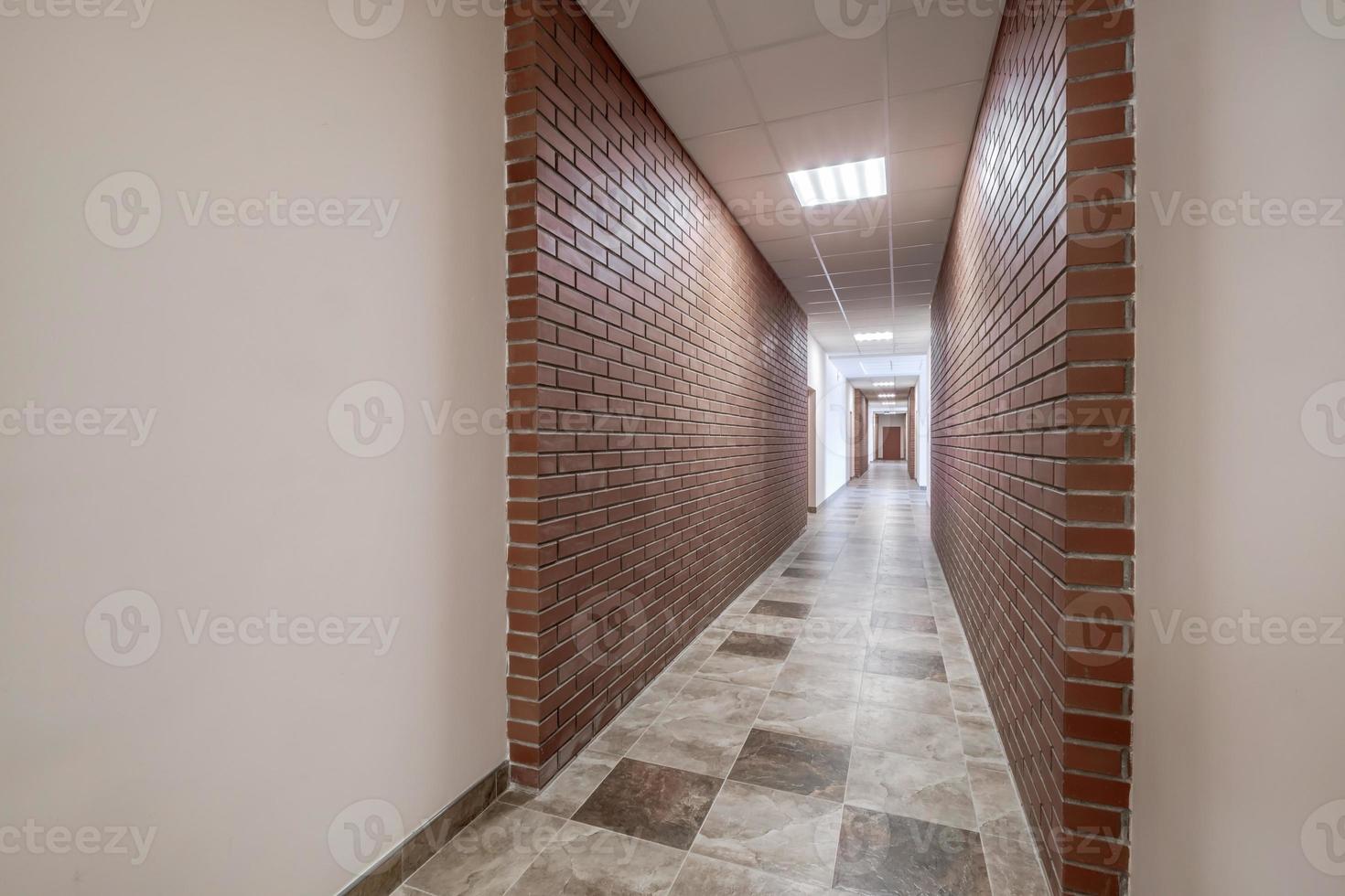 Weiß leeren lange Gang mit rot Backstein Wände und Türen im Innere von modern Wohnungen oder Büro foto