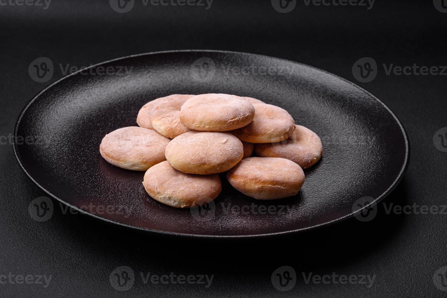 köstlich frisch gebacken Mahlzeit mit Getreide Shortcakes oder Kekse auf ein schwarz Teller foto